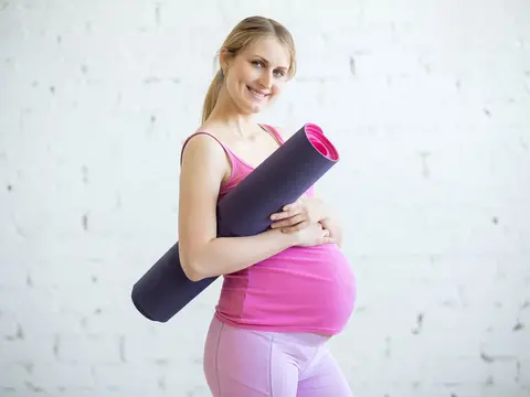 Schwangere macht Sport Schwangere Frau mit Jogamatte