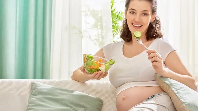 Schwangere Frau isst kleine Mahlzeit
